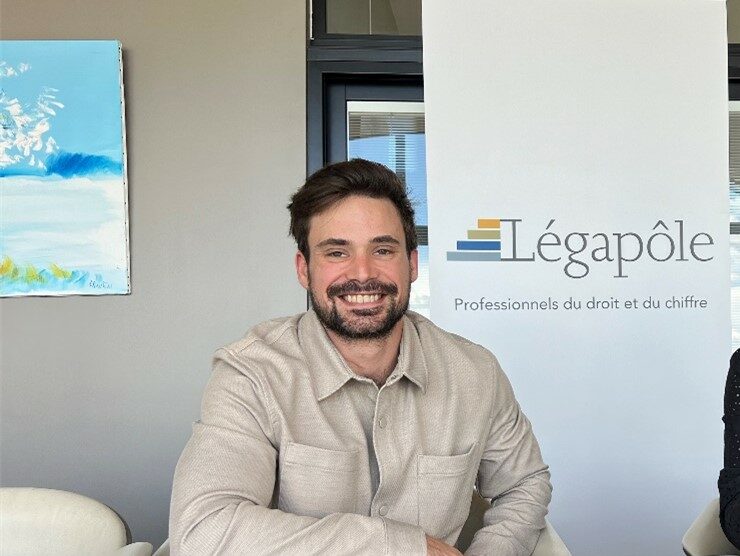 Deux personnes souriantes devant un panneau Légapôle.