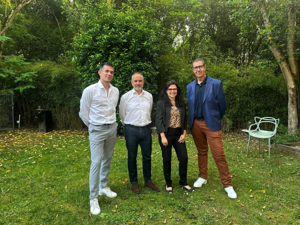 Quatre personnes posant ensemble en extérieur