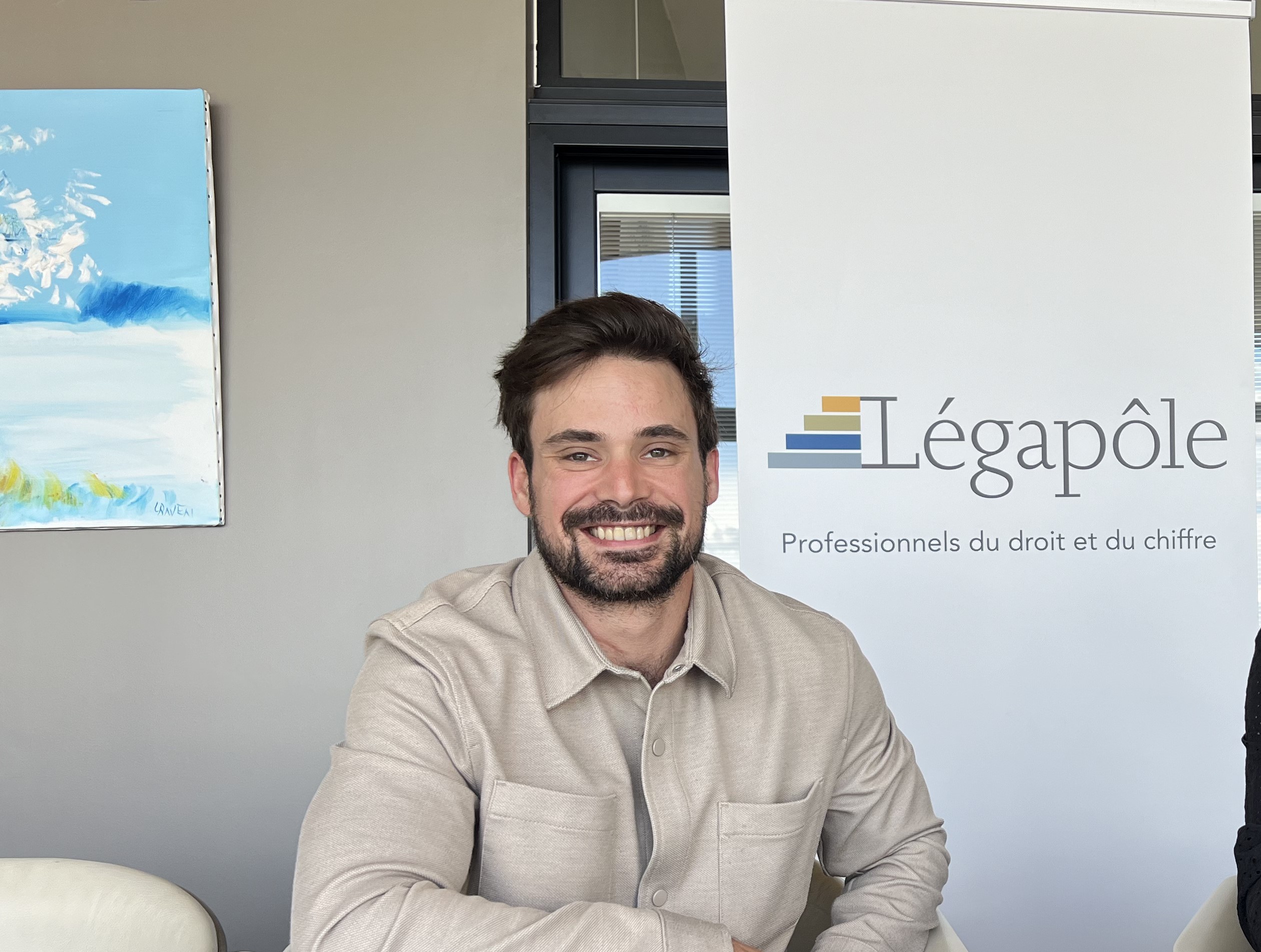 Homme souriant devant un panneau Légapôle.